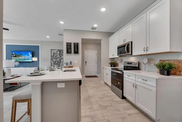 a kitchen with kitchen island a sink appliances and cabinets