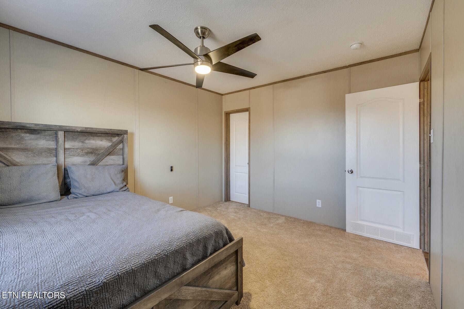 4501 Shipe Road Corryton, TN 37721 - Photo 23 of 32 a bedroom with a large bed and a ceiling fan