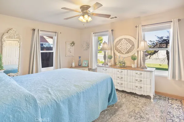 a bedroom with a bed a chandelier and dresser