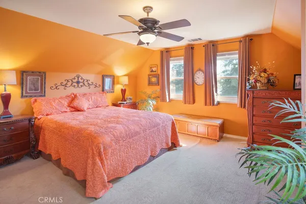 a spacious bedroom with a bed and a chandelier
