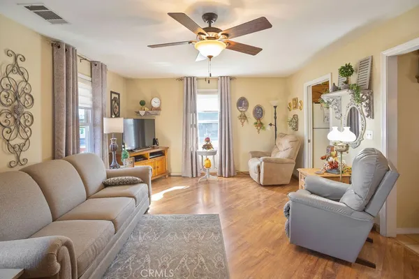 a living room with furniture ceiling fan and a window