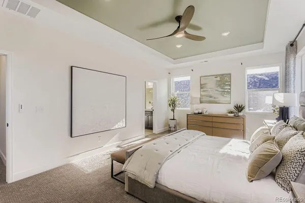 a spacious bedroom with a bed a chandelier and large mirror