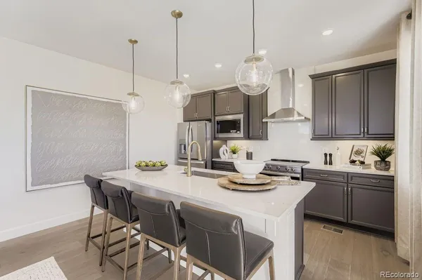 a kitchen with a table a sink cabinets and stainless steel appliances
