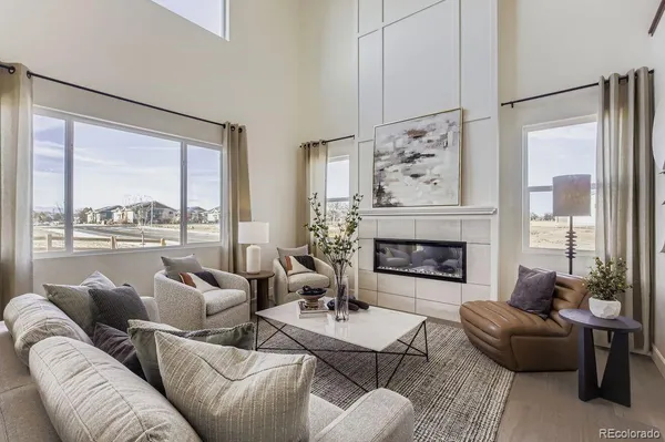 a living room with furniture a large window and a fireplace