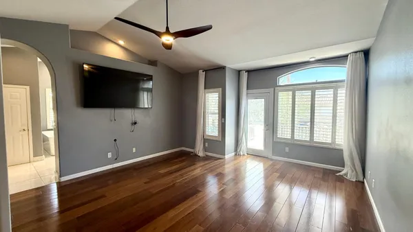 a view of livingroom with wooden floor and a flat screen tv