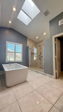 a spacious bathroom with a tub and large mirror