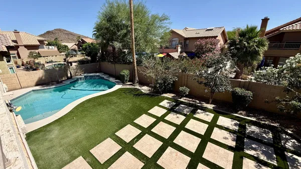 a view of a white house with a swimming pool and porch with furniture