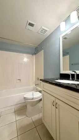 a bathroom with a double vanity sink a mirror and a bathtub