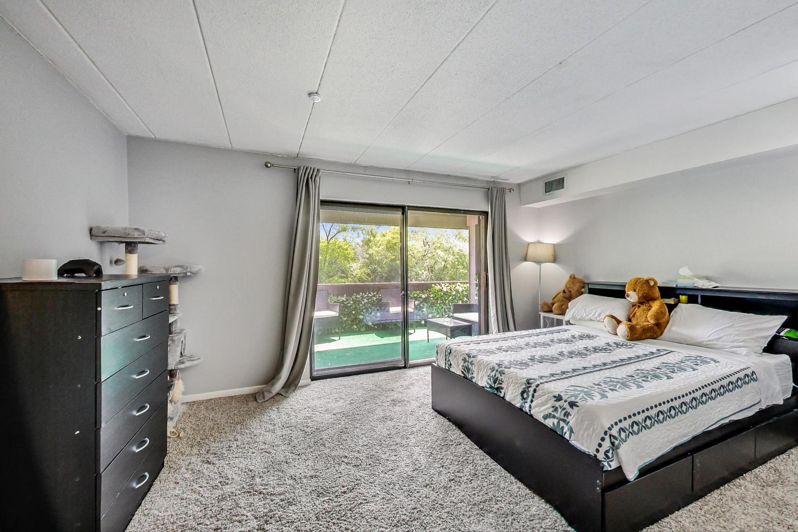 550 Timber Ridge Drive, Unit 304 Carol Stream, IL 60188 - Photo 13 of 22 a bedroom with a bed and wooden floor