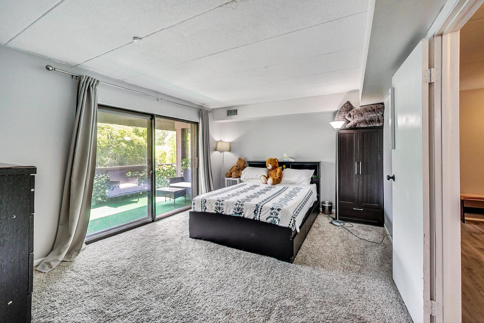 550 Timber Ridge Drive, Unit 304 Carol Stream, IL 60188 - Photo 14 of 22 a bedroom with a large bed and a window