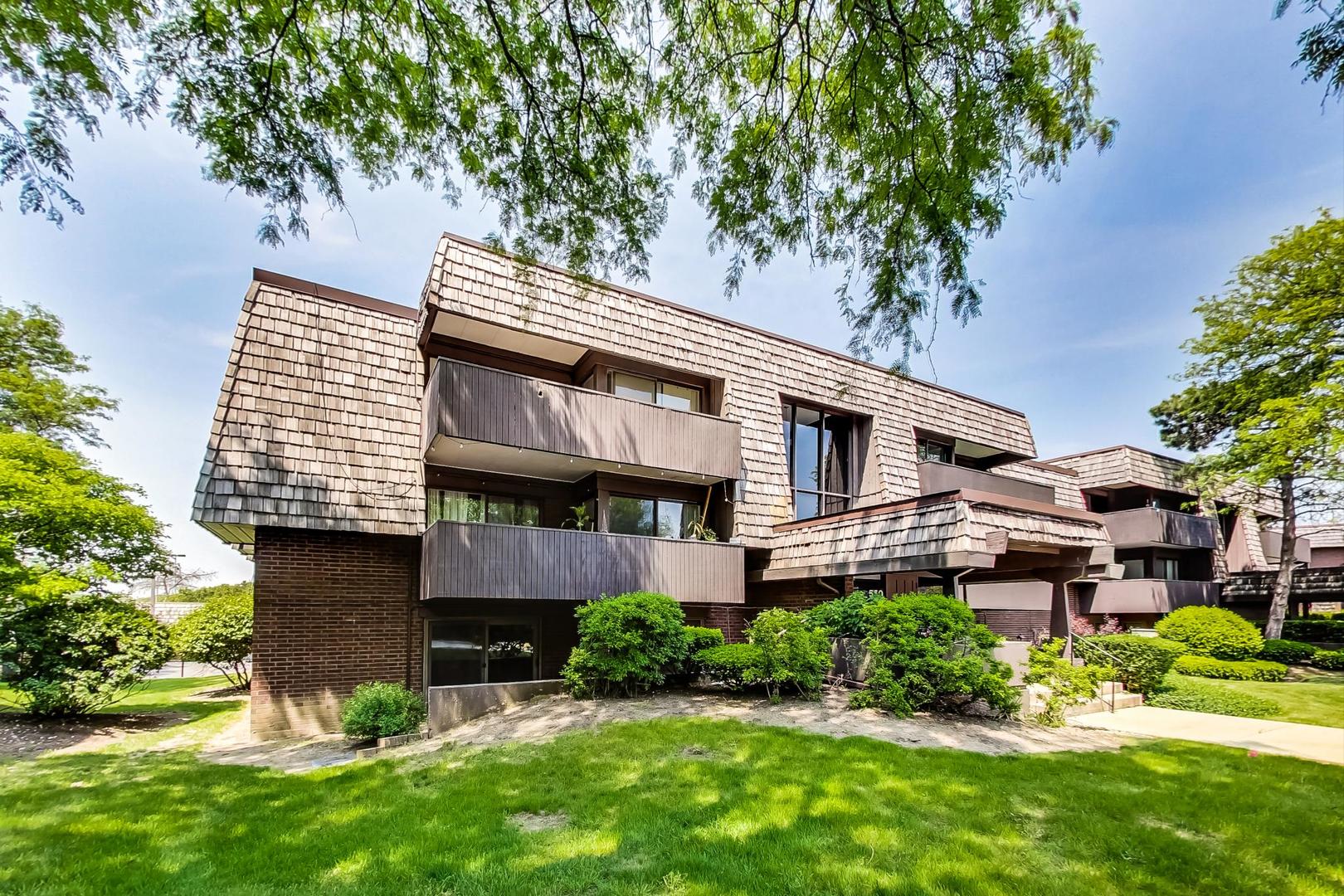 550 Timber Ridge Drive, Unit 304 Carol Stream, IL 60188 - Photo 2 of 22 a front view of a house with a garden and plants