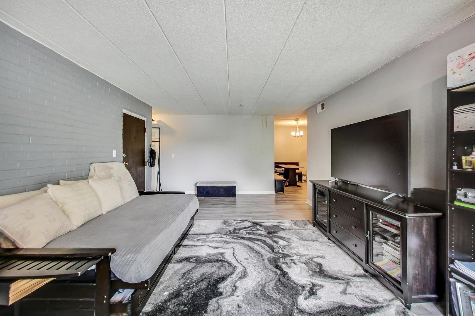 550 Timber Ridge Drive, Unit 304 Carol Stream, IL 60188 - Photo 7 of 22 a living room with furniture and a flat screen tv