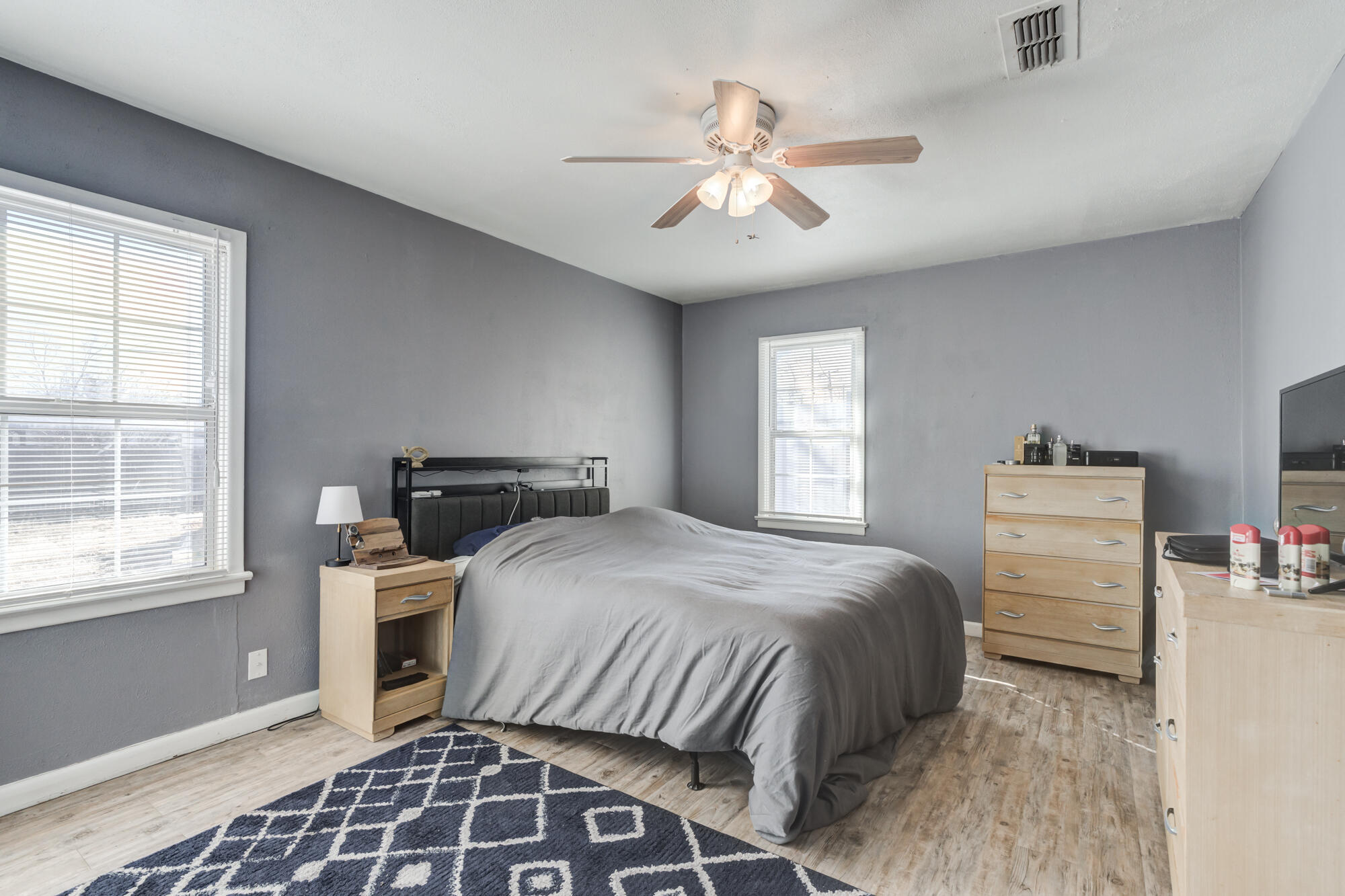 4503 45th Street Lubbock, TX 79414 - Photo 22 of 27 a bedroom with a bed and a chandelier
