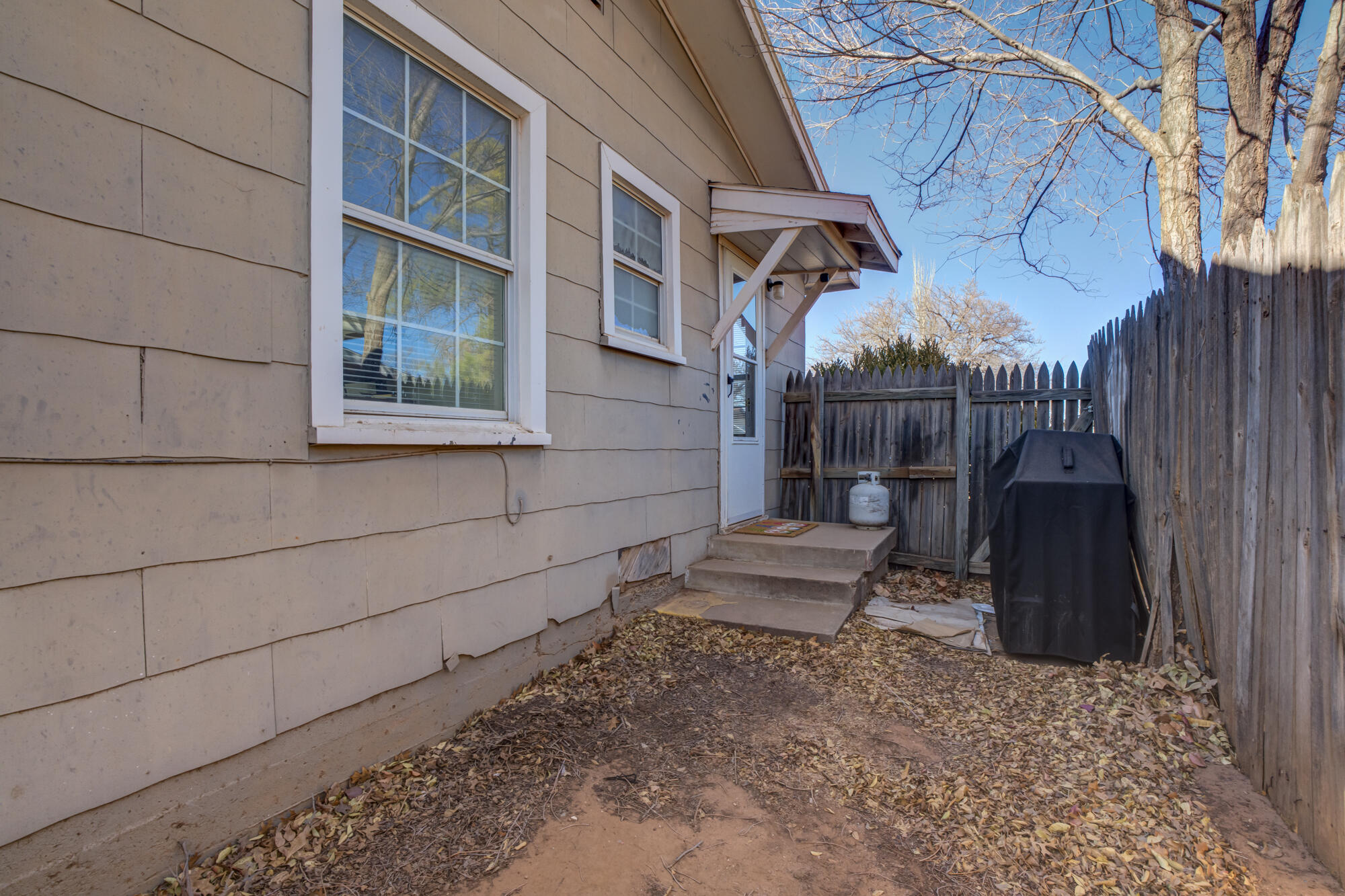 4503 45th Street Lubbock, TX 79414 - Photo 25 of 27 a view of a backyard with table and chairs and wooden fence