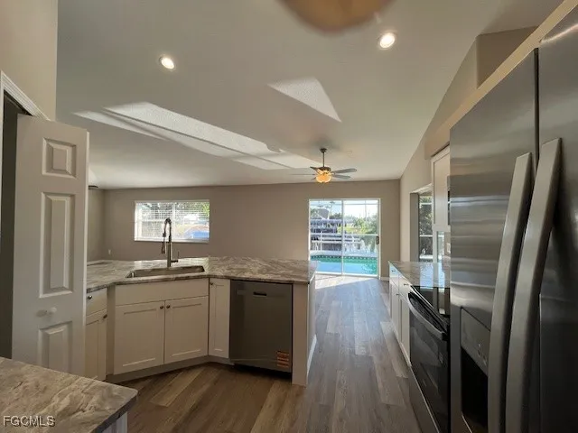 a kitchen with a sink stainless steel appliances and cabinets