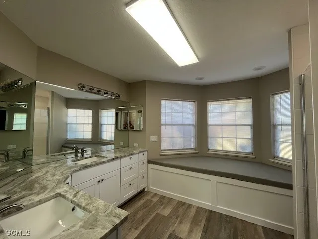 a bathroom with a granite countertop sink mirror toilet and bathtub