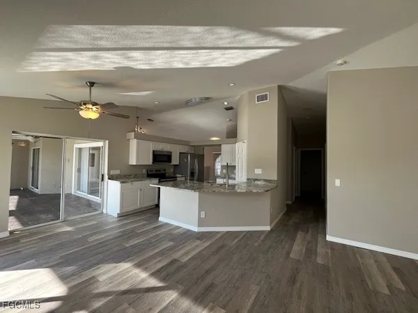 a large kitchen with cabinets a sink and a stove top oven