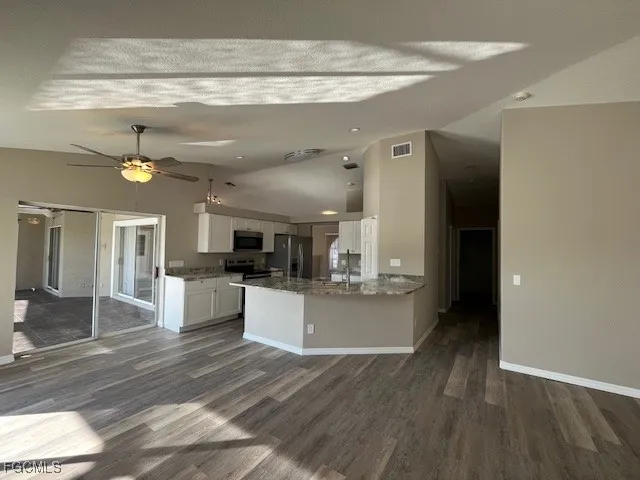 a large kitchen with cabinets a sink and a stove top oven