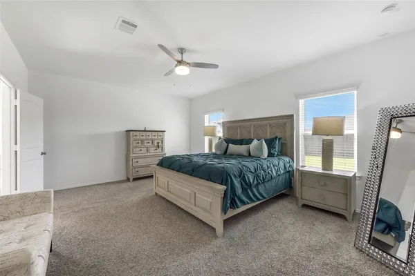 a bedroom with a large bed and a chandelier