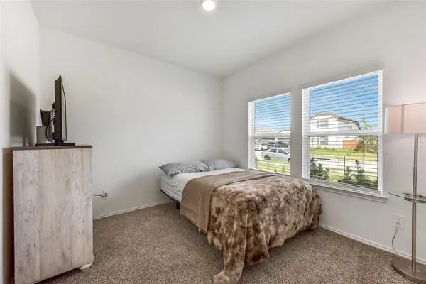 a bed sitting in a bedroom next to a window