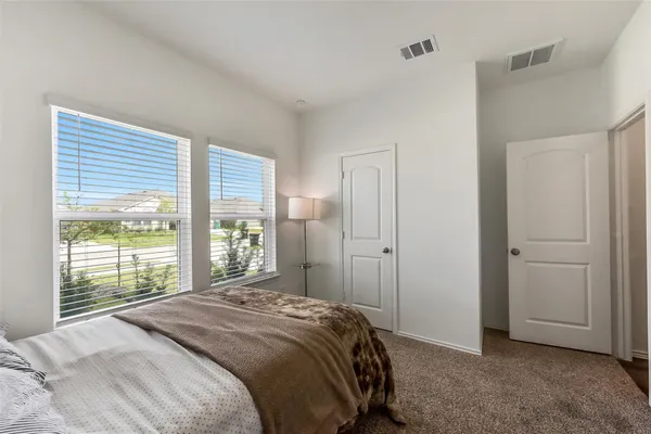 a bedroom with a bed and a large window
