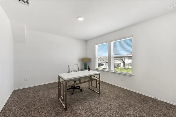a view of a workspace with furniture and a window