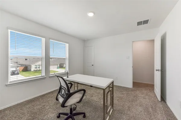 a view of a workspace with furniture and a window