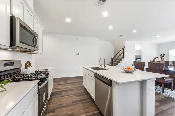 a kitchen with stainless steel appliances a sink a stove top oven a counter space and cabinets