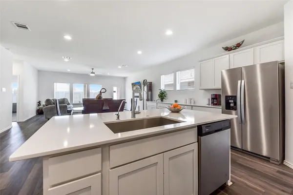 a kitchen with stainless steel appliances granite countertop a sink a refrigerator and a refrigerator