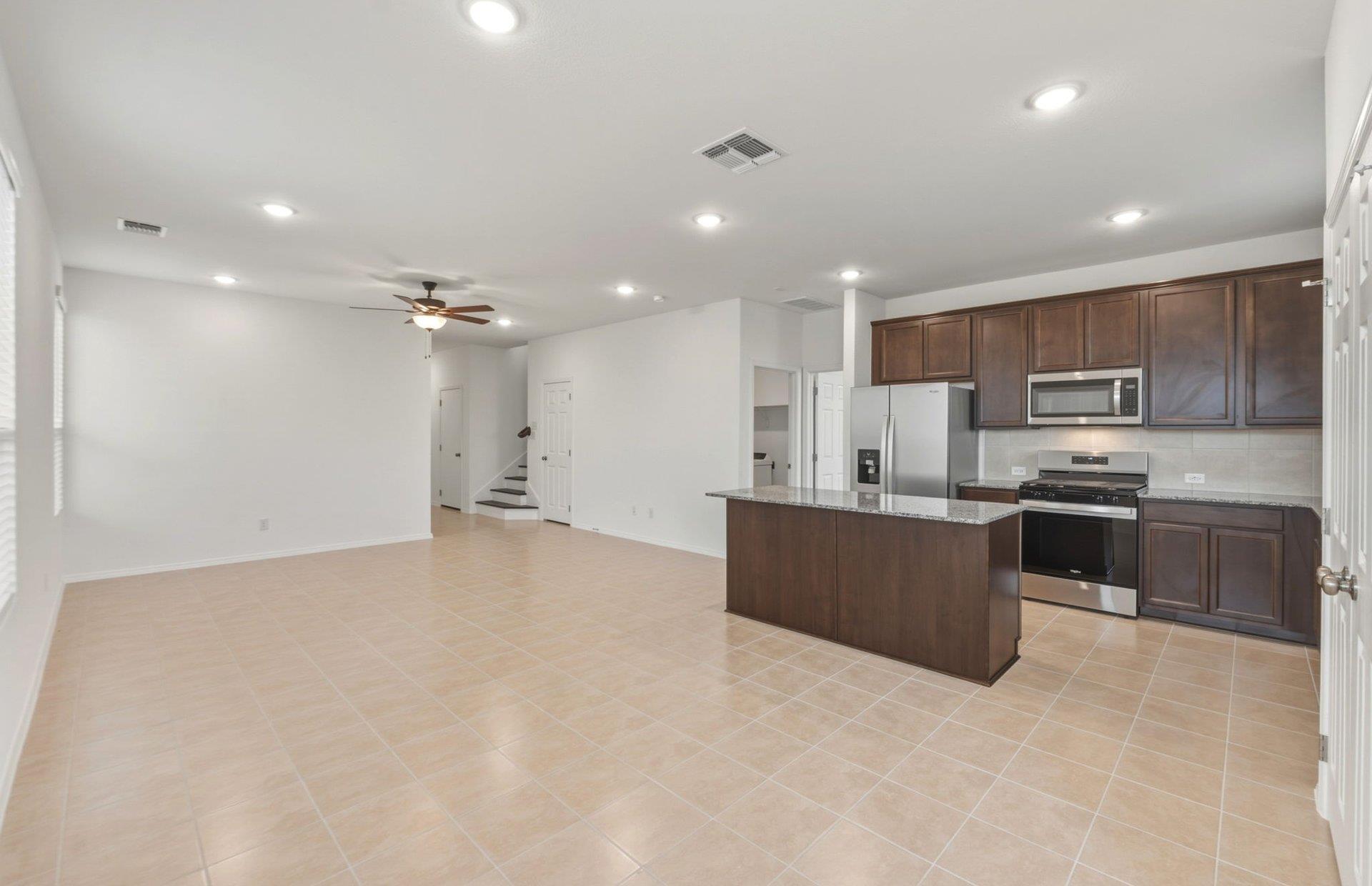 545 Henry Milton Road Georgetown, TX 78626 - Photo 4 of 33 Tiled flooring and recessed lighting connect the open kitchen with the casual living area.