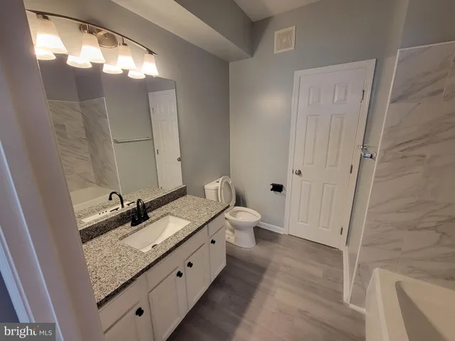 a bathroom with a double vanity sink and mirror with shower