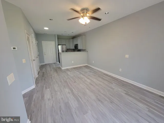 a view of a kitchen with wooden floor and a ceiling fan