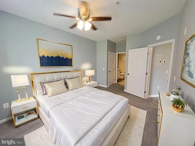 a spacious bedroom with a bed a chandelier and a dresser