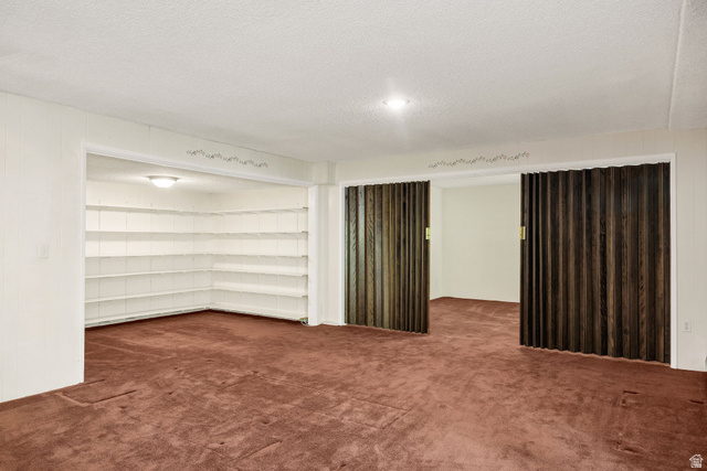 1365 Sumac Drive Logan, UT 84321 - Photo 33 of 66 Spacious room with plush carpeting, featuring built-in shelving, a recessed ceiling light, and bi-fold wood-finish doors