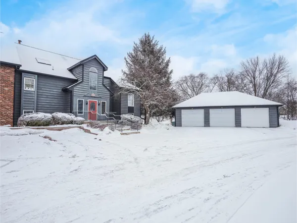 a front view of a house with a yard covered in snow