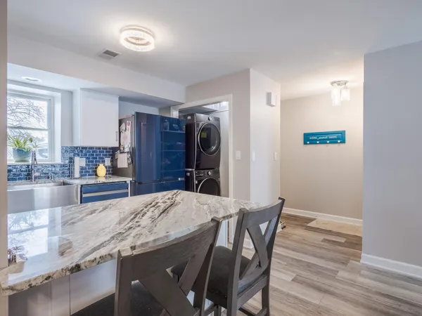a kitchen with granite countertop a refrigerator and wooden floor