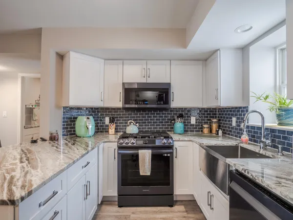 a kitchen with granite countertop a stove sink and cabinets