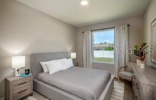 5900 Southwest 112th Pl Road Ocala, FL 34476 - Photo 12 of 17 a bedroom with a bed and a potted plant