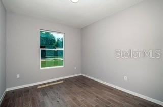 5900 Southwest 112th Pl Road Ocala, FL 34476 - Photo 15 of 17 an empty room with wooden floor and windows