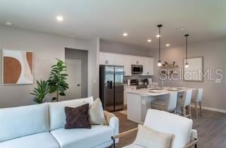 5900 Southwest 112th Pl Road Ocala, FL 34476 - Photo 5 of 17 a living room with furniture kitchen and a chandelier