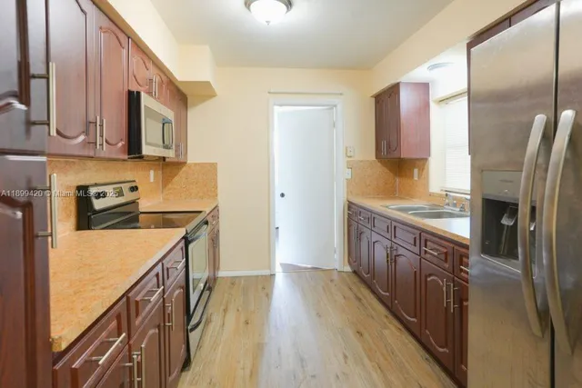 a kitchen with stainless steel appliances granite countertop a stove a sink and a microwave