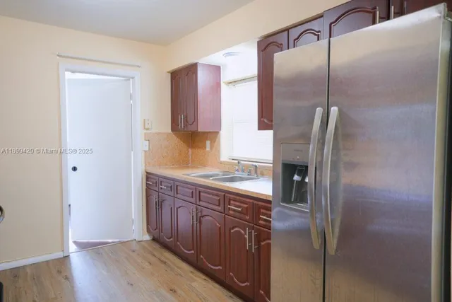 a kitchen with stainless steel appliances granite countertop a refrigerator and a sink