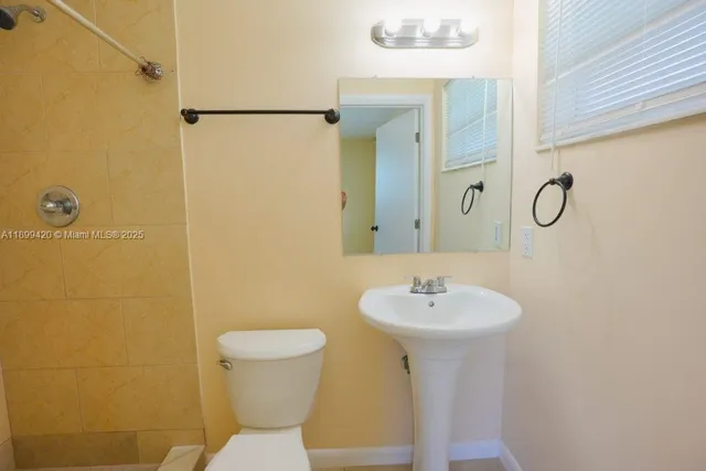a bathroom with a sink toilet and a mirror