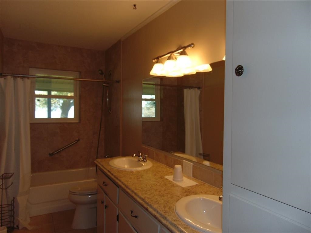 504 North Chaparral Burnet, TX 78611 - Photo 4 of 10 a bathroom with a granite countertop sink toilet and shower