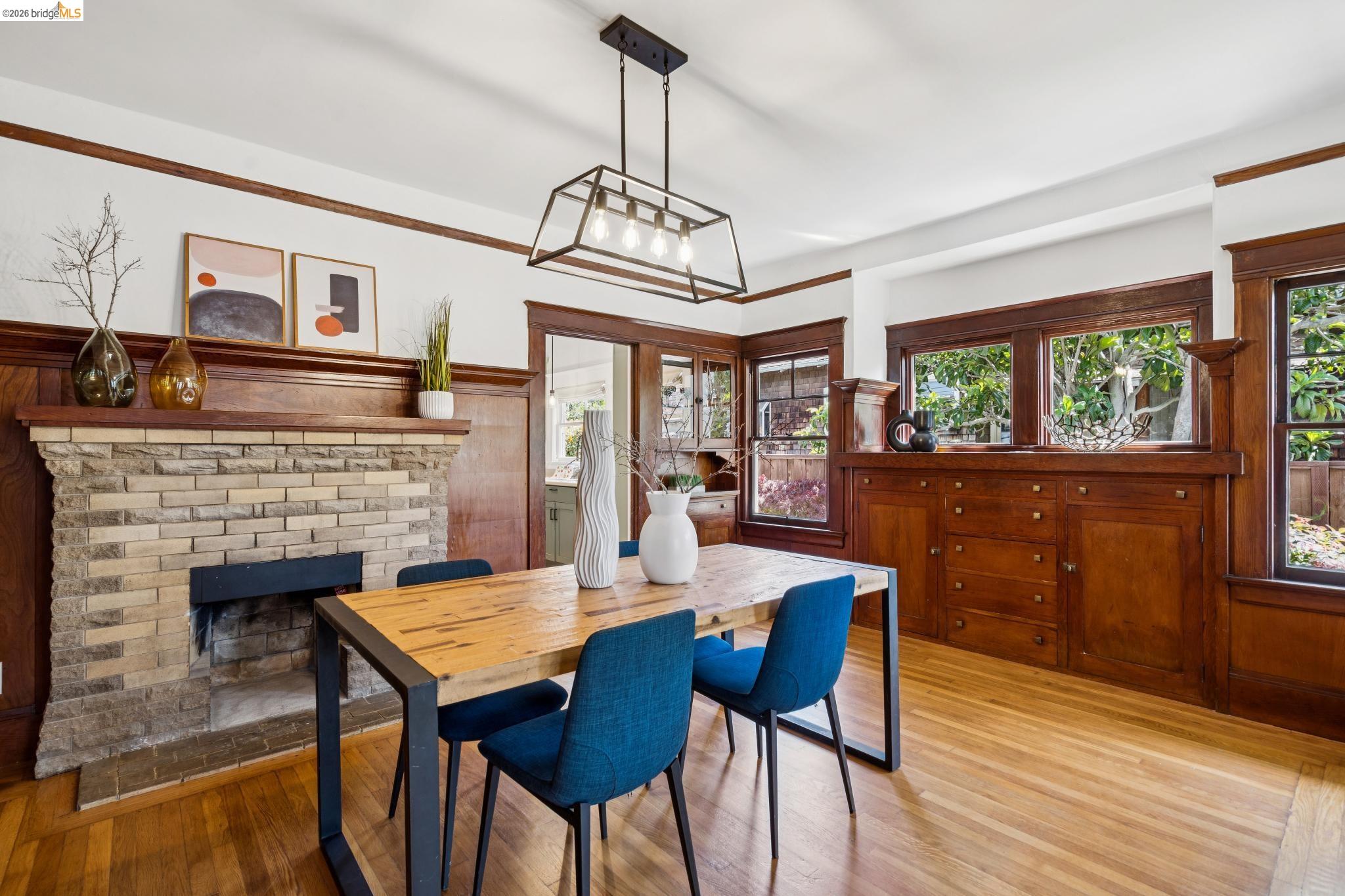 1701 Derby Street Berkeley, CA 94703 - Photo 12 of 39 Dining area featuring a stone brick fireplace, wood-finish flooring, and extensive wood paneling