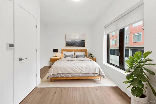 a bedroom with a bed and a potted plant