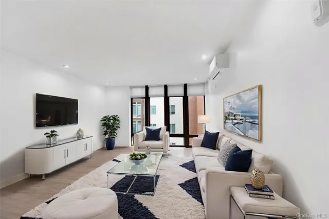 a living room with furniture a flat screen tv and a large window