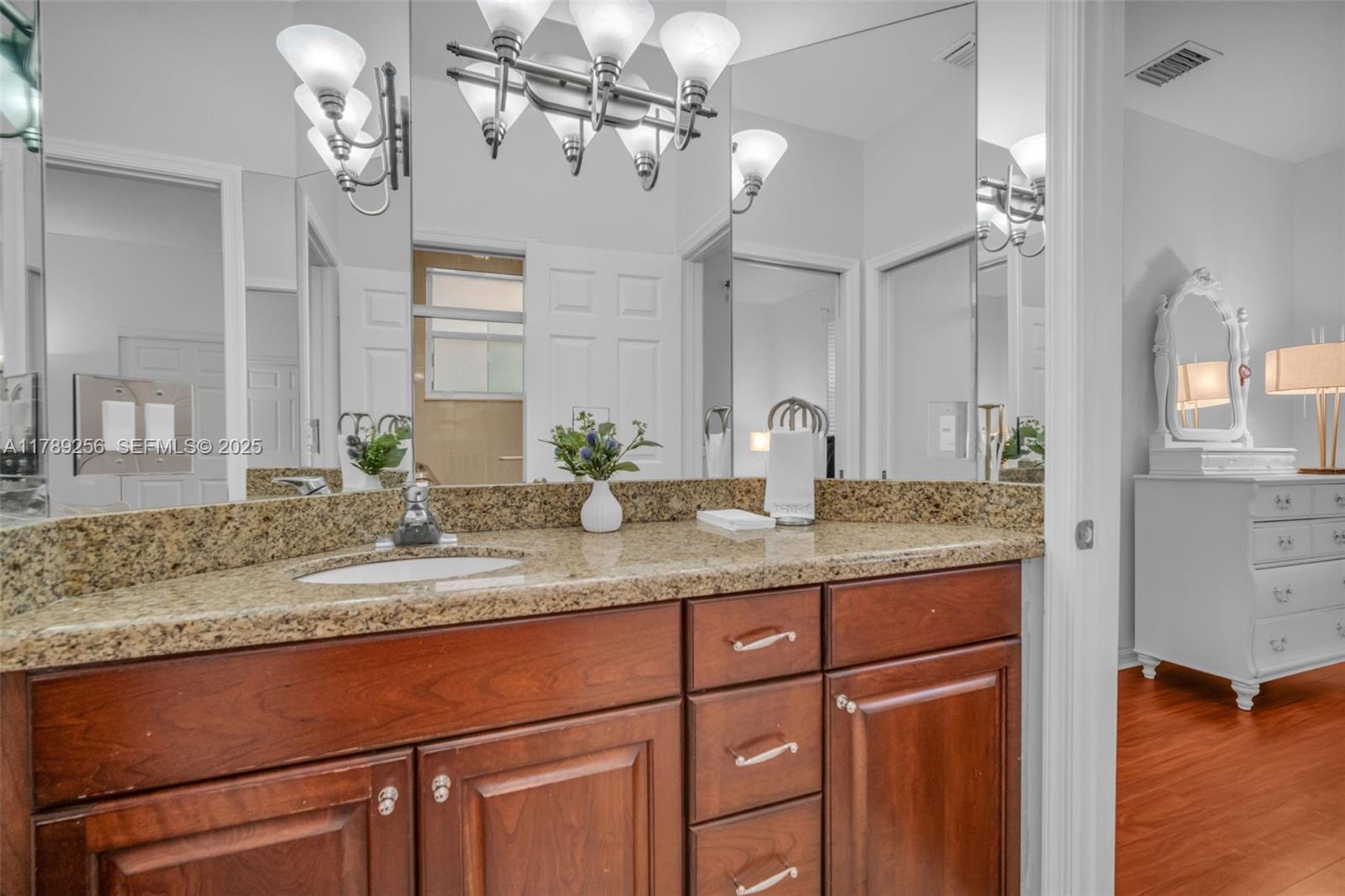 3739 Oak Ridge Circle Weston, FL 33331 - Photo 55 of 71 a bathroom with a granite countertop sink a light fixture and a mirror