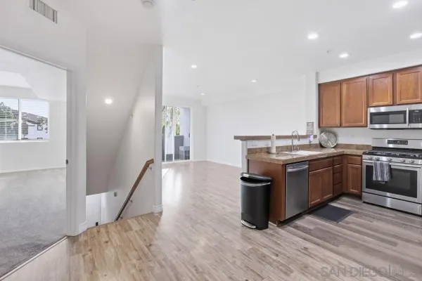a kitchen with stainless steel appliances granite countertop a stove a sink and a refrigerator
