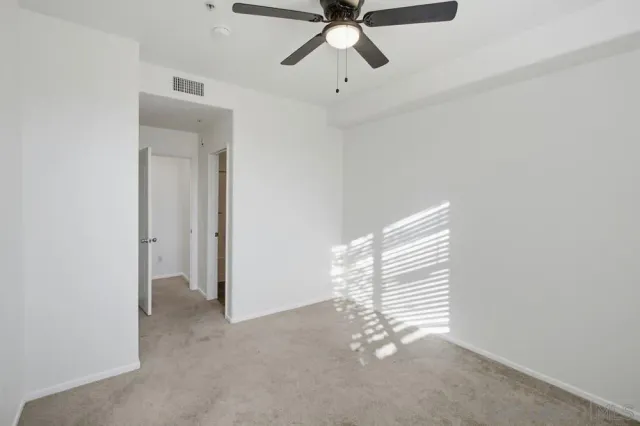 an empty room with a ceiling fan and a window